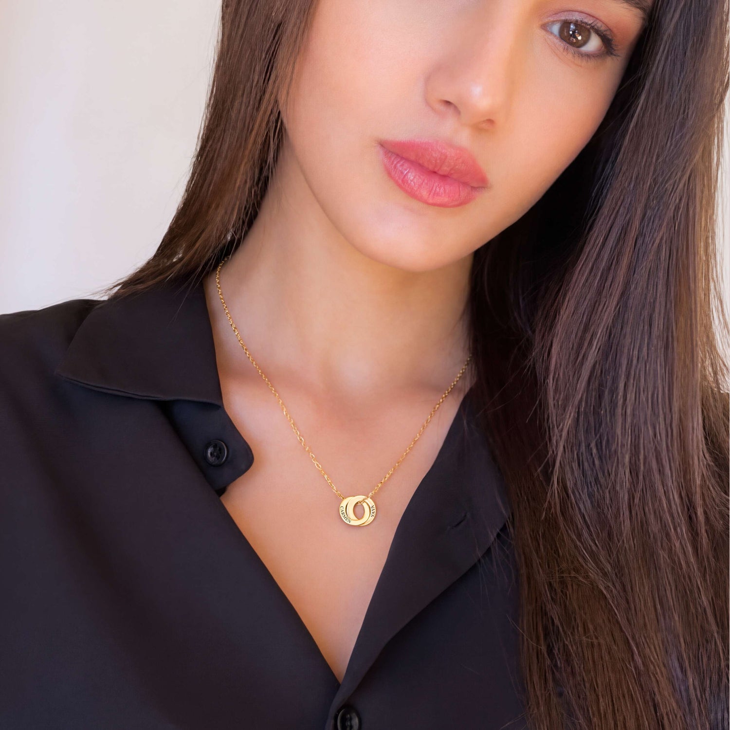 The personalized Amity necklace with two linked rings, worn in gold tone